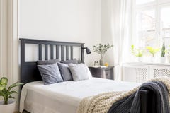 Coussins et couverture sur le lit avec la tête de lit noire dans l'inte de chambre à coucher photographie stock libre de droits Coussins et couverture sur le lit avec la tête de lit noire dans l'inte de chambre à coucher photographie stock libre de droits