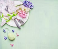 Couvert de table de Pâques avec les fleurs et l'oeuf sur le fond vert clair, vue supérieure Photographie stock libre de droits Couvert de table de Pâques avec les fleurs et l'oeuf sur le fond vert clair, vue supérieure Photographie stock libre de droits