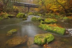 River with a covered bridge in a forest in autumn stock photo River with a covered bridge in a forest in autumn stock photo