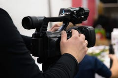 Covering an event with a video camera. Videographer films with video camera. Camera operator working indoors royalty free stock photos Covering an event with a video camera. Videographer films with video camera. Camera operator working indoors royalty free stock photos