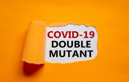 Covid-19 double mutant symbol. Words `Covid-19 double mutant` appearing behind torn orange paper. Medical and COVID-19 pandemic