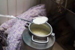 Cozinhando o requeijão e o queijo em casa O homem cria o leite do queijo, do aquecimento e o soro em uma bandeja de alumínio fotos de stock Cozinhando o requeijão e o queijo em casa O homem cria o leite do queijo, do aquecimento e o soro em uma bandeja de alumínio fotos de stock