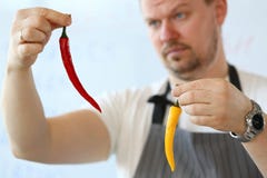 Cozinheiro chefe profissional Showing Yellow Chili Pepper imagens de stock royalty free Cozinheiro chefe profissional Showing Yellow Chili Pepper imagens de stock royalty free