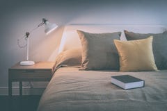Cozy bedroom interior with book and reading lamp on bedside table stock photography Cozy bedroom interior with book and reading lamp on bedside table stock photography
