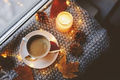 Cozy winter or autumn morning at home. Hot coffee with gold metallic spoon, warm blanket, garland and candle lights royalty free stock photos Cozy winter or autumn morning at home. Hot coffee with gold metallic spoon, warm blanket, garland and candle lights royalty free stock photos