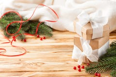 Craft gift boxes with white ribbon, bow, green Christmas tree, decorations, white plaid on wooden background. Xmas and New Year co stock photos Craft gift boxes with white ribbon, bow, green Christmas tree, decorations, white plaid on wooden background. Xmas and New Year co stock photos