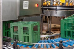 Crates are transported to conveyor belt and moved to the filling line royalty free stock photo Crates are transported to conveyor belt and moved to the filling line royalty free stock photo