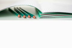 Crayons ? c?t? du carnet d'?cole photos stock Crayons ? c?t? du carnet d'?cole photos stock
