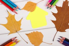 Crayons, forme du bâtiment et feuilles automnales sur les conseils blancs Image libre de droits Crayons, forme du bâtiment et feuilles automnales sur les conseils blancs Image libre de droits