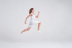 Crazy joyful girl in summer dress jumping isolated over background stock images Crazy joyful girl in summer dress jumping isolated over background stock images