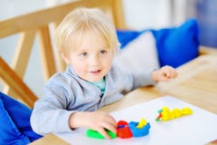Creative boy playing with colorful modeling clay at kindergarten Stock Images Creative boy playing with colorful modeling clay at kindergarten Stock Images