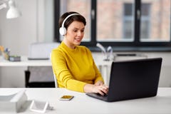 Creative woman in headphones with laptop at office royalty free stock photo Creative woman in headphones with laptop at office royalty free stock photo