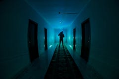 Creepy Silhouette In The Dark Abandoned Building. Dark Corridor With Cabinet Doors And Lights With Silhouette Of Spooky Horror Per Stock Photography Creepy Silhouette In The Dark Abandoned Building. Dark Corridor With Cabinet Doors And Lights With Silhouette Of Spooky Horror Per Stock Photography