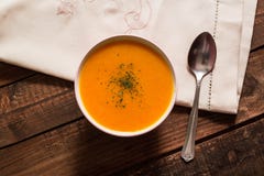 Crema de la calabaza con las cebolletas y el perejil en la tabla de madera fotografía de archivo libre de regalías Crema de la calabaza con las cebolletas y el perejil en la tabla de madera fotografía de archivo libre de regalías