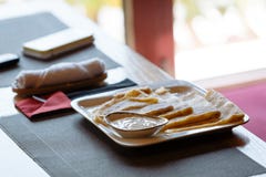 Crepes con crema agria en la placa de la casilla blanca en la tabla fotografía de archivo libre de regalías Crepes con crema agria en la placa de la casilla blanca en la tabla fotografía de archivo libre de regalías