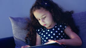 Crian?a bonito que diverte a tabuleta A menina que passa o tempo de lazer que joga o jogo m?vel no e esmaga o brilhante filme Crian?a bonito que diverte a tabuleta A menina que passa o tempo de lazer que joga o jogo m?vel no e esmaga o brilhante filme
