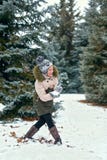 Criança da menina que tem o divertimento na floresta do inverno, paisagem bonita com abeto nevados fotografia de stock Criança da menina que tem o divertimento na floresta do inverno, paisagem bonita com abeto nevados fotografia de stock
