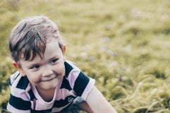 A criança feliz, rapaz pequeno olha para baixo, olhar pensativo e realizar nas mãos os crescimentos fora Espaço para o texto Retr fotos de stock A criança feliz, rapaz pequeno olha para baixo, olhar pensativo e realizar nas mãos os crescimentos fora Espaço para o texto Retr fotos de stock