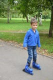 Criança pequena bonito, menino, patinando no parque, primavera imagens de stock Criança pequena bonito, menino, patinando no parque, primavera imagens de stock