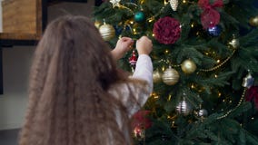 Criança que decora a árvore de Natal com brinquedos Criança que decora a árvore de Natal com brinquedos
