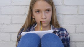 Criança que escreve, estudando, criança pensativa, estudante pensativo Learning Schoolgirl fotografia de stock Criança que escreve, estudando, criança pensativa, estudante pensativo Learning Schoolgirl fotografia de stock