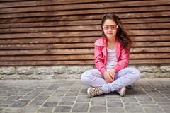 Criança à moda da menina que veste um revestimento cor-de-rosa do verão ou do outono, calças de brim brancas, óculos de sol Fotografia de Stock Criança à moda da menina que veste um revestimento cor-de-rosa do verão ou do outono, calças de brim brancas, óculos de sol Fotografia de Stock