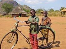 Crianças africanas pobres com a vila remota África da bicicleta velha foto de stock Crianças africanas pobres com a vila remota África da bicicleta velha foto de stock