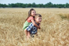 Crianças em uma caminhada em um campo de trigo imagem de stock Crianças em uma caminhada em um campo de trigo imagem de stock