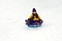 Crianças felizes que sledding a tubulação jogo do irmão e da irmã junto no inverno as crianças deslizam para baixo o monte as cri foto de stock Crianças felizes que sledding a tubulação jogo do irmão e da irmã junto no inverno as crianças deslizam para baixo o monte as cri foto de stock