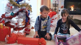 Crianças que abrem seus presentes do Natal Crianças que abrem seus presentes do Natal