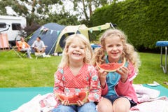 Crianças que apreciam o piquenique enquanto no feriado de acampamento da família foto de stock Crianças que apreciam o piquenique enquanto no feriado de acampamento da família foto de stock
