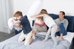Crianças que lutam descansos, família que têm o quarto do divertimento, pais com filha e filho alegre junto foto de stock Crianças que lutam descansos, família que têm o quarto do divertimento, pais com filha e filho alegre junto foto de stock
