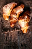 Croissants d'or frais sur le fond rustique foncé Photographie stock libre de droits Croissants d'or frais sur le fond rustique foncé Photographie stock libre de droits