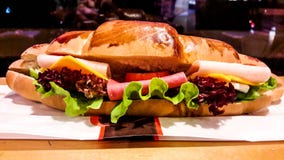 Croissantsandwich met ham, cheddarkaas, kersentomaat en greens stock afbeeldingen Croissantsandwich met ham, cheddarkaas, kersentomaat en greens stock afbeeldingen