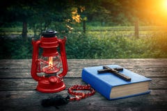 Croix chrétienne en bois sur la bible, la lampe de kérosène brûlante et les perles de prière sur la vieille table Salut d'âme et image stock Croix chrétienne en bois sur la bible, la lampe de kérosène brûlante et les perles de prière sur la vieille table Salut d'âme et image stock