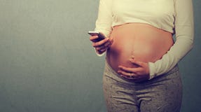 Cropped closeup image young pregnant woman texting on mobile phone stock photo Cropped closeup image young pregnant woman texting on mobile phone stock photo