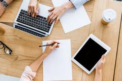 cropped image of colleagues working on startup project in office with tablet royalty free stock photo cropped image of colleagues working on startup project in office with tablet royalty free stock photo