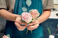 Cropped image of Female Florist at work. Arranging various flowers in bouquet. Close up flowers in hand. Florist workplace. Floral stock images Cropped image of Female Florist at work. Arranging various flowers in bouquet. Close up flowers in hand. Florist workplace. Floral stock images
