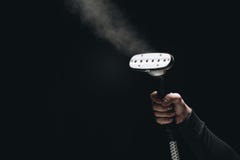 cropped shot of person holding garment steamer with steam royalty free stock photo cropped shot of person holding garment steamer with steam royalty free stock photo