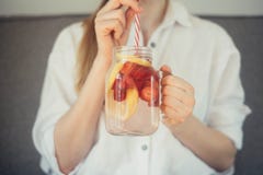 cropped shot of young woman drinking home made fresh summer drink from mason jar with straw stock photos cropped shot of young woman drinking home made fresh summer drink from mason jar with straw stock photos