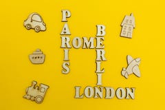 Crossword of the names of the cities: `Paris, London, Berlin, Rome` on a yellow background. Wooden figures of an airplane, a tra royalty free stock images Crossword of the names of the cities: `Paris, London, Berlin, Rome` on a yellow background. Wooden figures of an airplane, a tra royalty free stock images
