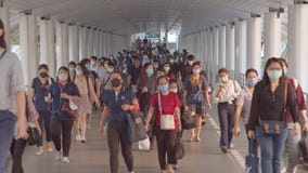 Crowded Asian people wear face mask walking in pedestrian walkway. Coronavirus disease Covid-19 pandemic outbreak
