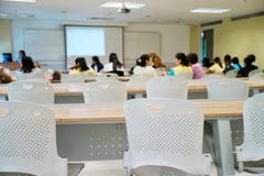 Crowded people attending the seminar event. Empty chairs in the classroom with blurred students in stock photos Crowded people attending the seminar event. Empty chairs in the classroom with blurred students in stock photos