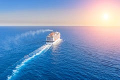 Cruise Ship Liner Goes Into Horizon The Blue Sea Leaving A Plume On The Surface Of The Water Seascape During Sunset. Aerial View, Stock Photos Cruise Ship Liner Goes Into Horizon The Blue Sea Leaving A Plume On The Surface Of The Water Seascape During Sunset. Aerial View, Stock Photos