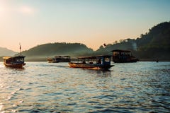 Cruzeiro do por do sol no prabang do luang no Mekong River A luz suave bateu os barcos na água A maioria deles estão em um cruzei foto de stock Cruzeiro do por do sol no prabang do luang no Mekong River A luz suave bateu os barcos na água A maioria deles estão em um cruzei foto de stock