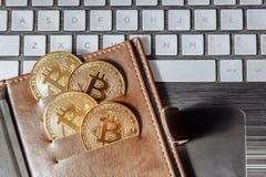 Crypto currency coins in leather wallet on the laptop keyboard. stock photo Crypto currency coins in leather wallet on the laptop keyboard. stock photo