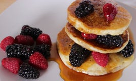 Crêpes délicieuses de sirop d'érable avec des baies photographie stock libre de droits Crêpes délicieuses de sirop d'érable avec des baies photographie stock libre de droits
