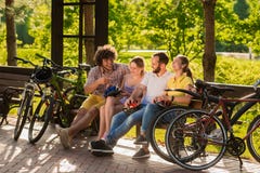 Cuatro amigos que tienen resto en parque imagen de archivo Cuatro amigos que tienen resto en parque imagen de archivo