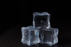 Cubes de glace claire sur une table noire images stock Cubes de glace claire sur une table noire images stock