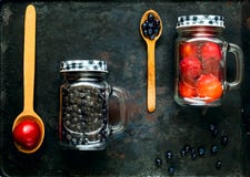 Cucharas de madera y frutas clasificadas del baya y rojas en el tarro de cristal en el fondo de metales oxidados viejos, concepto foto de archivo Cucharas de madera y frutas clasificadas del baya y rojas en el tarro de cristal en el fondo de metales oxidados viejos, concepto foto de archivo